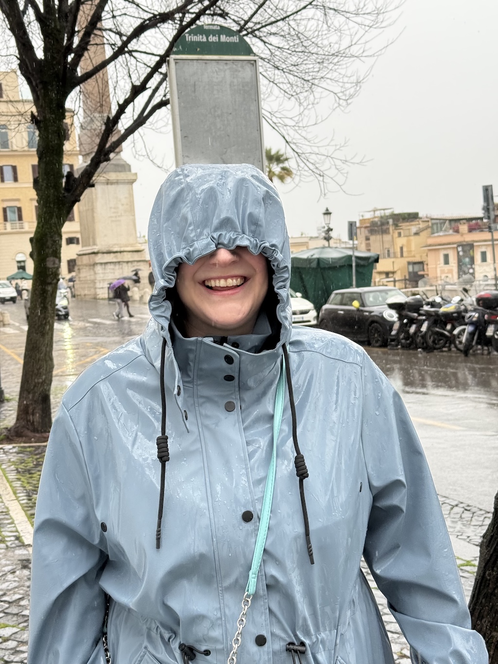 My partner in a rain coat, smiling while being utterly soaked by the weather