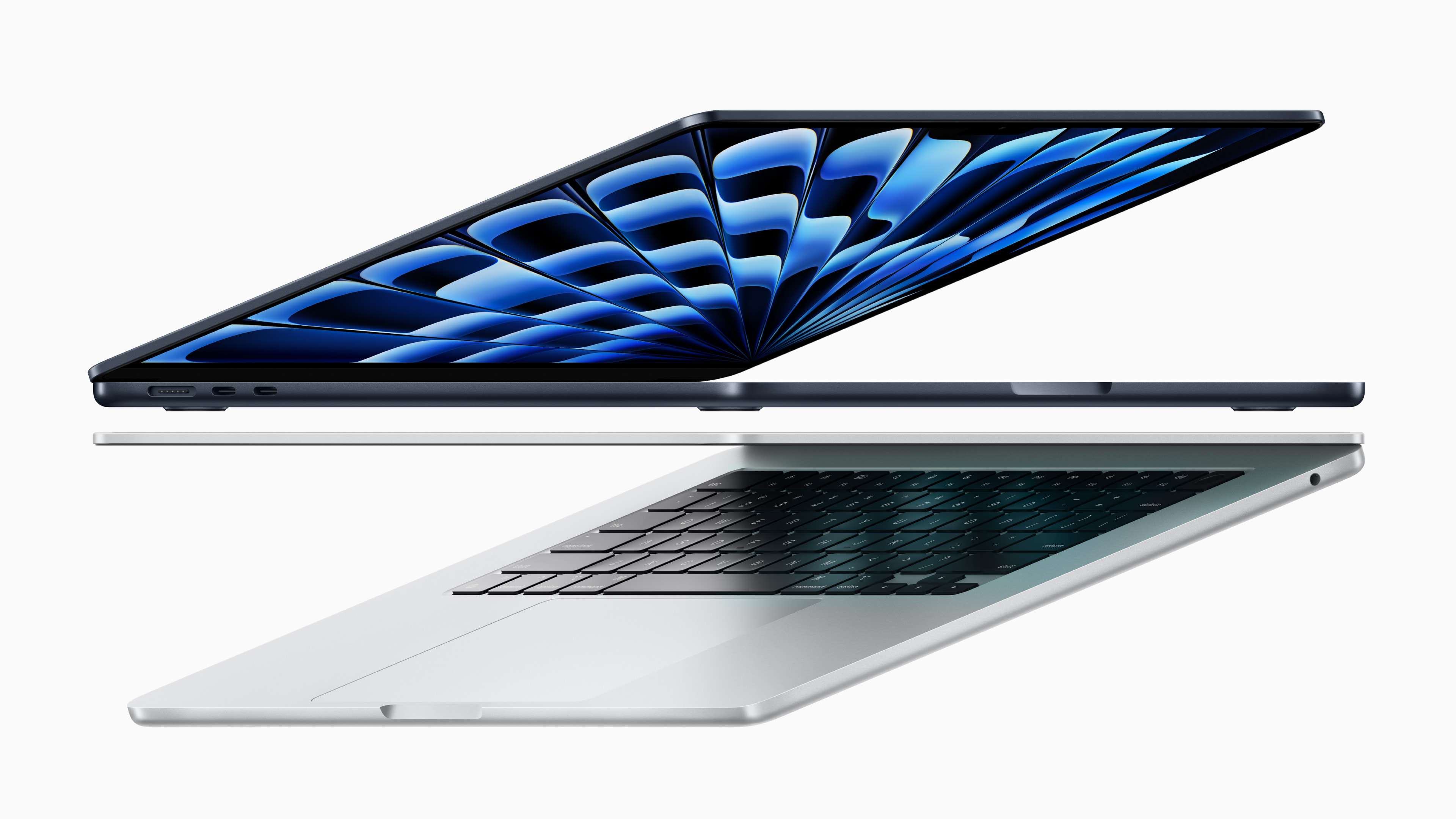 Two MacBook Airs semi-open, suspended in air